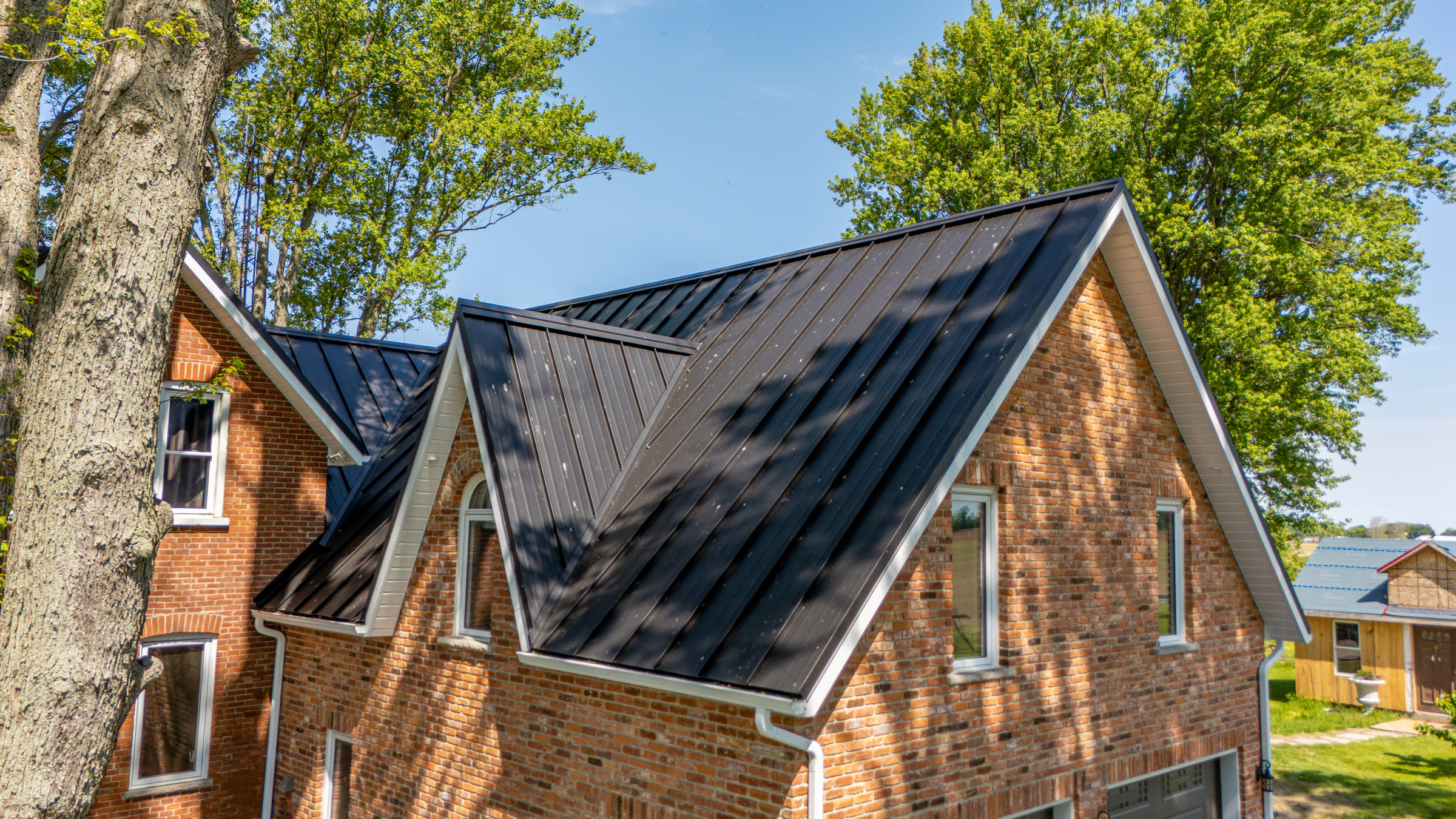 Close aerial view of Victorian home gables with a completed dark SS550 SnapLock metal roof in Dresden Ontario