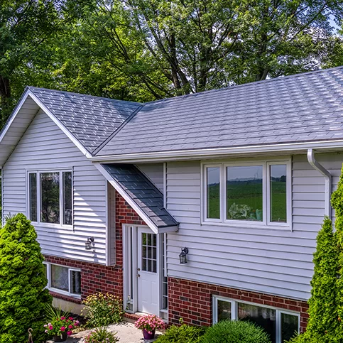 Suburban home with ATAS metal shingle roofing and white horizontal siding — CountryTowne installation combining modern durability with classic curb appeal.