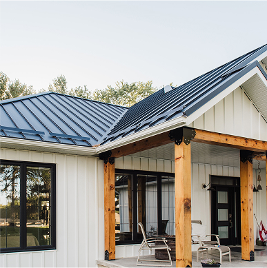 Modern farmhouse with white Lock Board & Batten metal siding and black SnapLock standing seam roof — a premium CountryTowne build with clean lines and rustic warmth.
