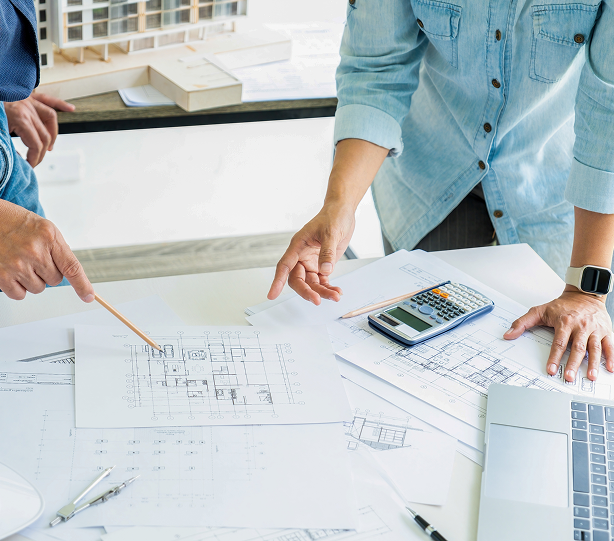 Architects in London Ontario reviewing metal siding and roofing blueprints at a design meeting for a commercial project