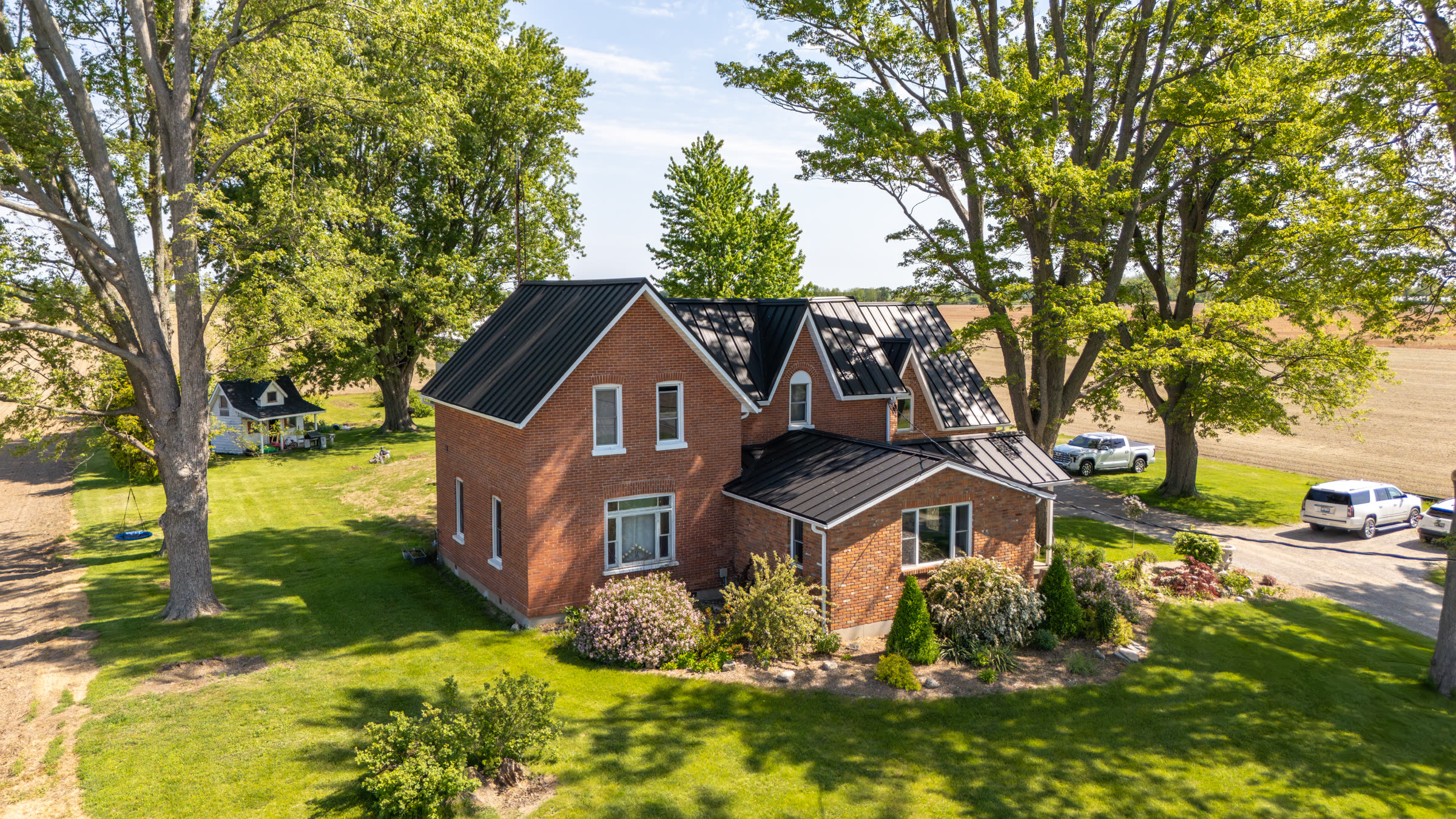 Aerial view of a Victorian brick home in Dresden Ontario with a completed dark SS550 SnapLock standing-seam metal roof