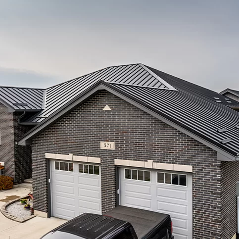 Brick residential home with black standing seam metal roofing — a sleek and durable CountryTowne installation with modern curb appeal.