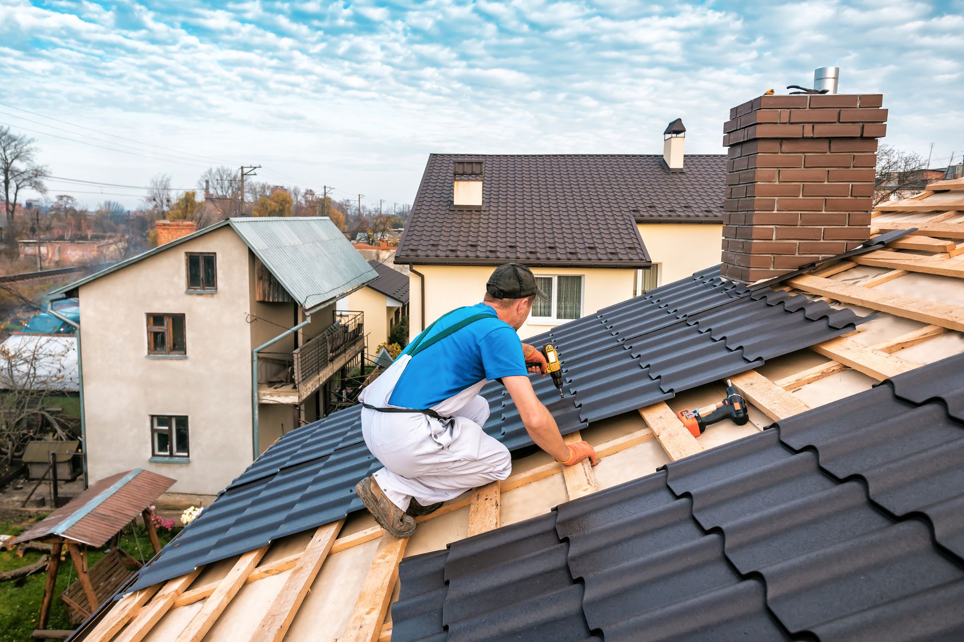 A roofer installing a metal shingle roof.